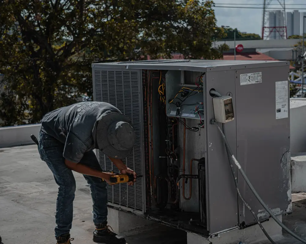 Técnico realizando manutenção em condensadora de ar-condicionado